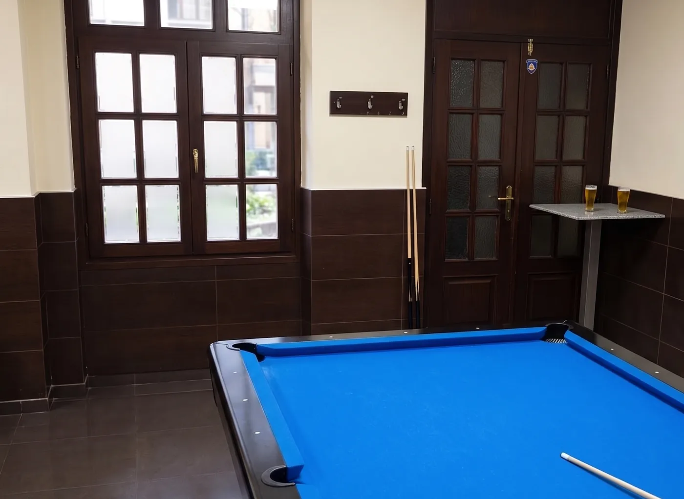 A sala de jogos do Café Académico, com a mesa de bilhar de pano azul